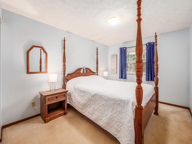 bedroom with a textured ceiling and light colored carpet