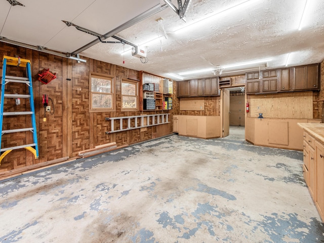 garage with wooden walls and a garage door opener