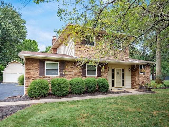 front of property with a garage, a front lawn, and an outdoor structure