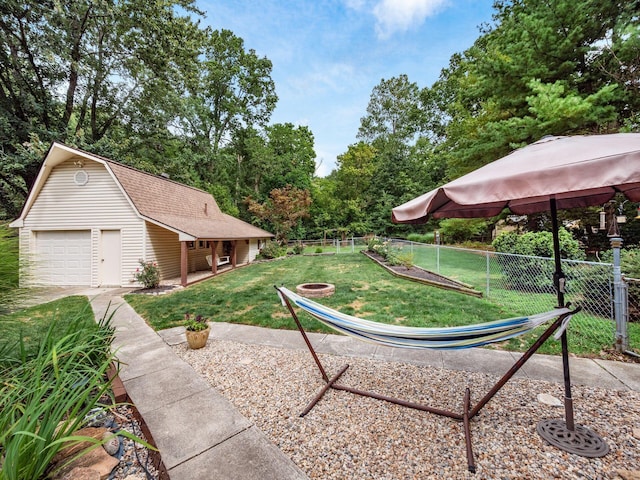 view of yard with a garage and an outbuilding