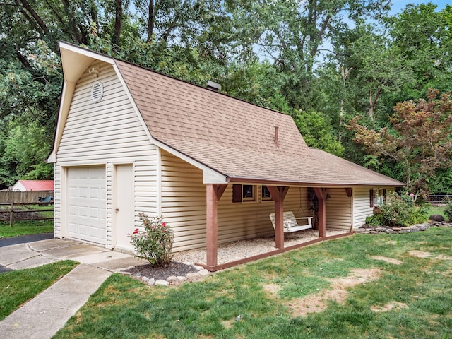 view of front of house with an outdoor structure, a front yard, and a garage