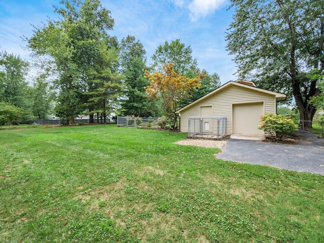 view of yard with a garage and an outbuilding