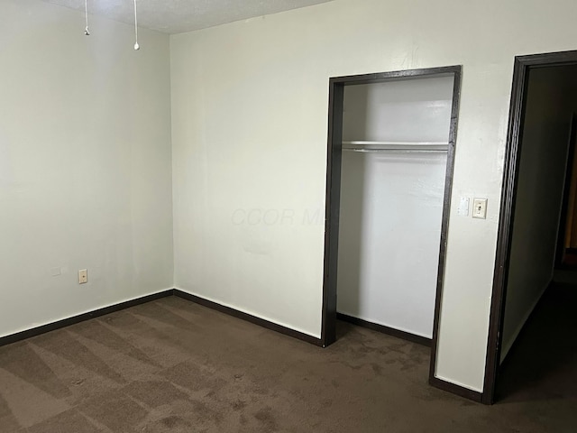 unfurnished bedroom with dark carpet