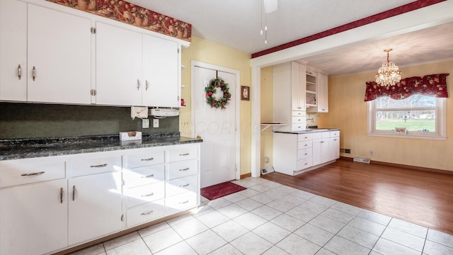 kitchen with white cabinets, dark stone countertops, and light tile patterned floors