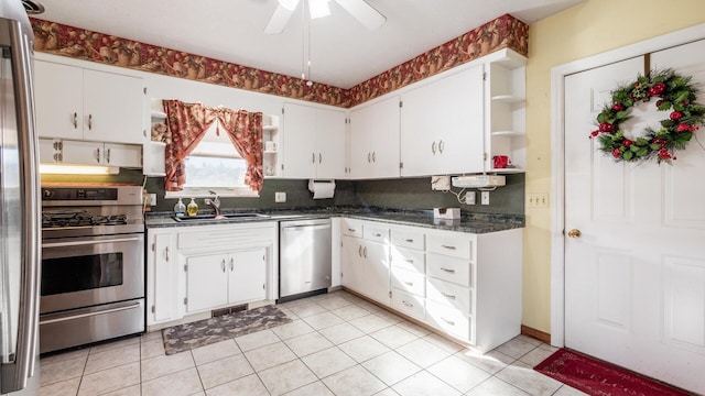 kitchen featuring white cabinetry, sink, light tile patterned floors, and appliances with stainless steel finishes