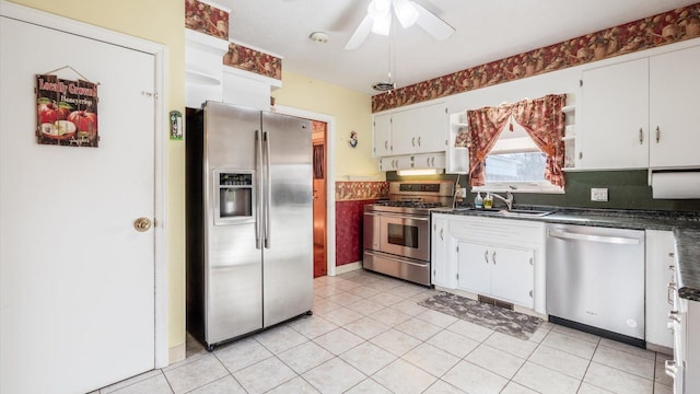 kitchen featuring ceiling fan, sink, light tile patterned floors, white cabinets, and appliances with stainless steel finishes