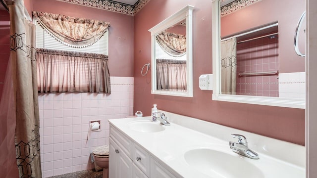 bathroom featuring vanity, tile walls, and toilet