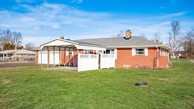 back of property featuring a yard, a garage, and a carport