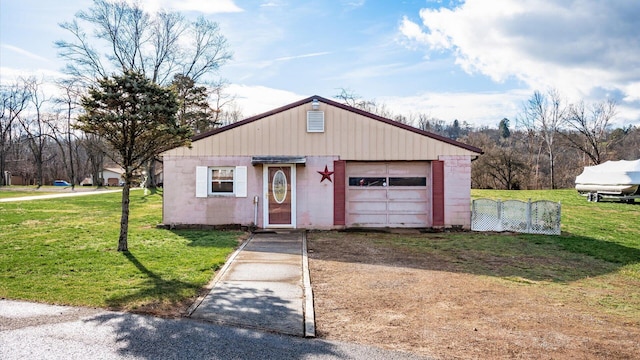 exterior space featuring a garage, a front lawn, and an outdoor structure