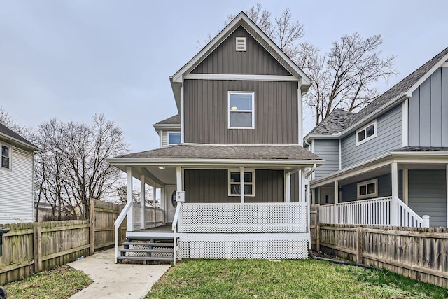 back of property featuring a lawn and covered porch