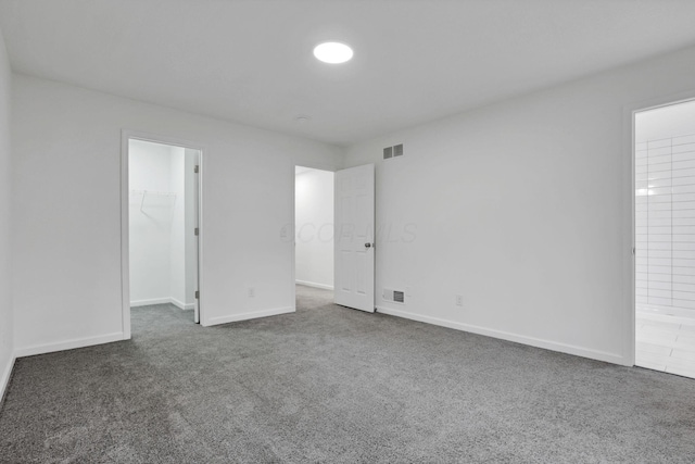 unfurnished room with dark colored carpet