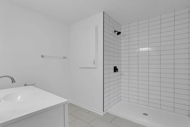 bathroom featuring a tile shower and vanity