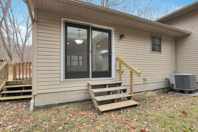 view of exterior entry with central AC and a wooden deck