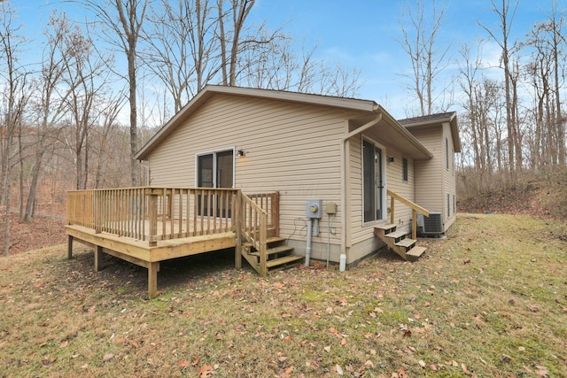 exterior space featuring a yard, a deck, and central air condition unit