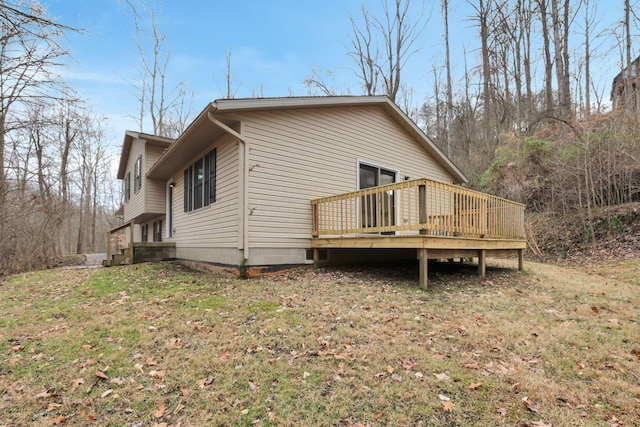 view of side of property featuring a lawn and a wooden deck