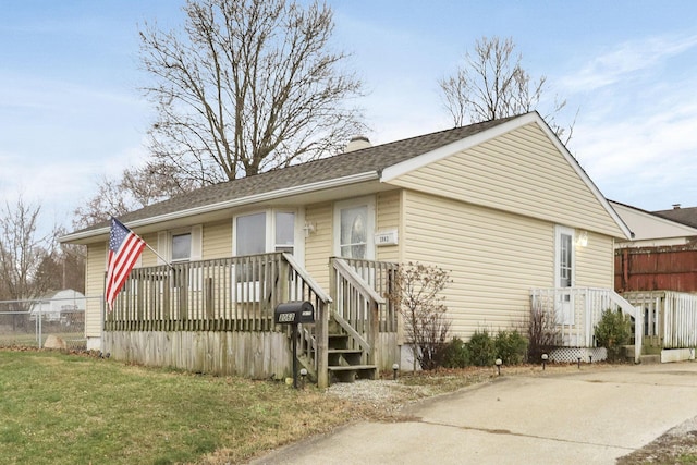 view of front of property featuring a wooden deck and a front yard