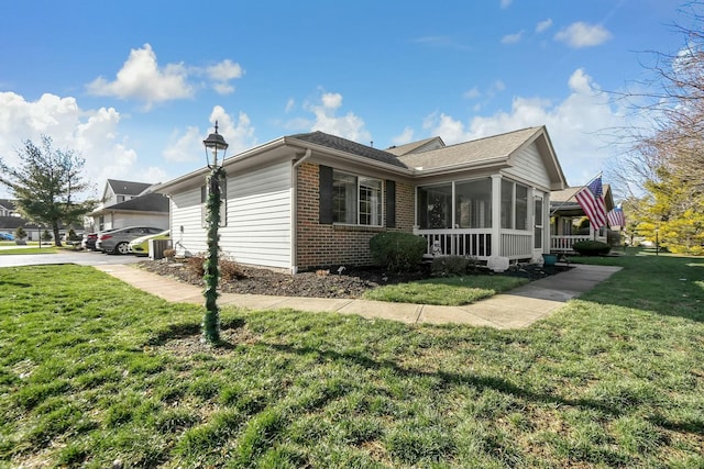 view of front of property featuring a sunroom and a front lawn