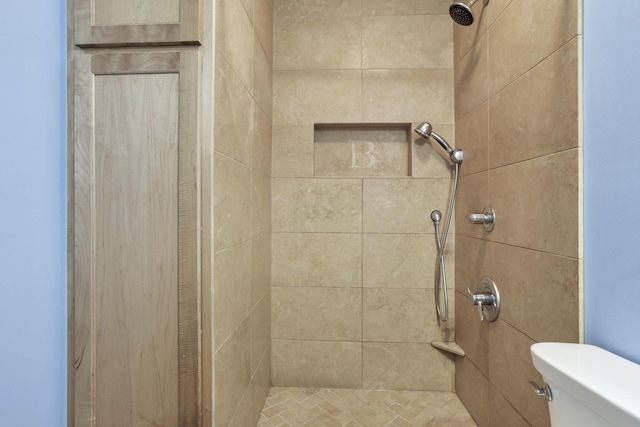 bathroom with toilet and a tile shower