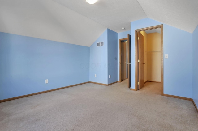 bonus room featuring light carpet and vaulted ceiling