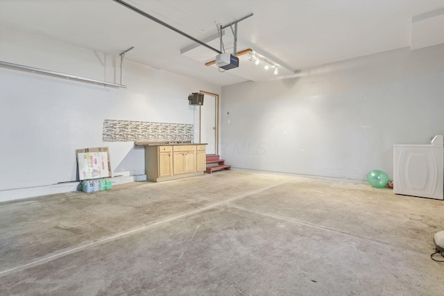 garage featuring washer / clothes dryer and a garage door opener