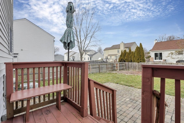 wooden deck featuring a lawn and a patio