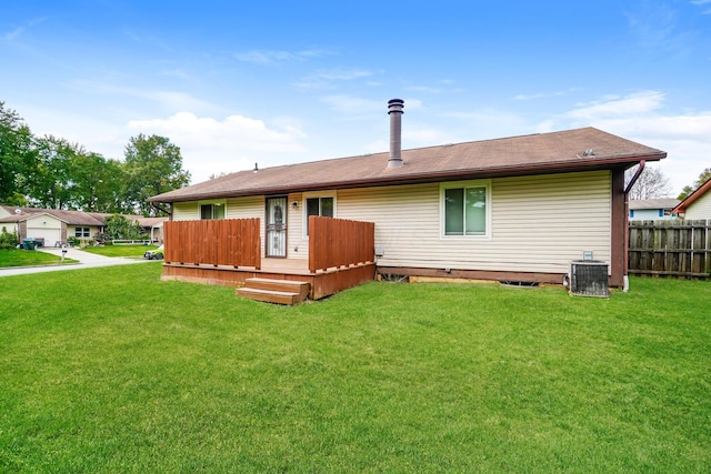 rear view of property featuring a lawn, central air condition unit, and a deck