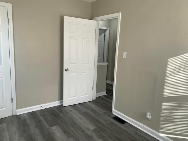 unfurnished bedroom with dark hardwood / wood-style floors