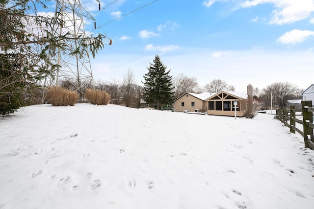 yard covered in snow with a sunroom