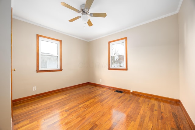 spare room featuring ceiling fan, wood-type flooring, and ornamental molding