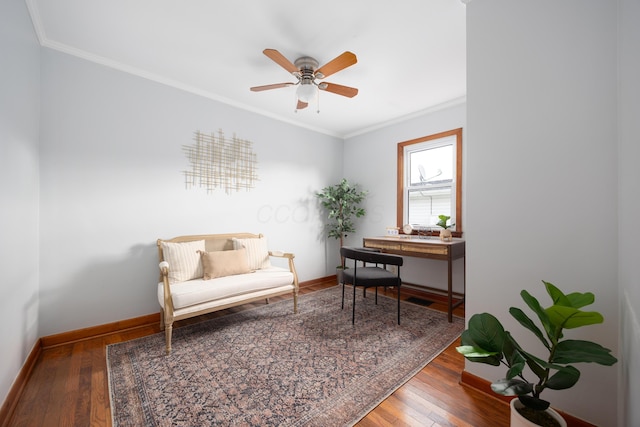 sitting room with hardwood / wood-style floors, ceiling fan, and crown molding