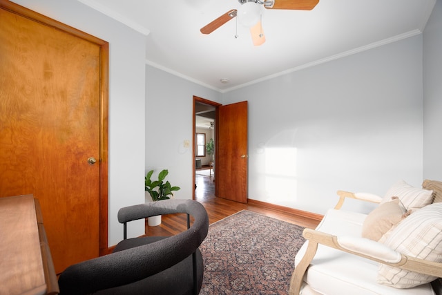 sitting room with wood-type flooring, ceiling fan, and crown molding