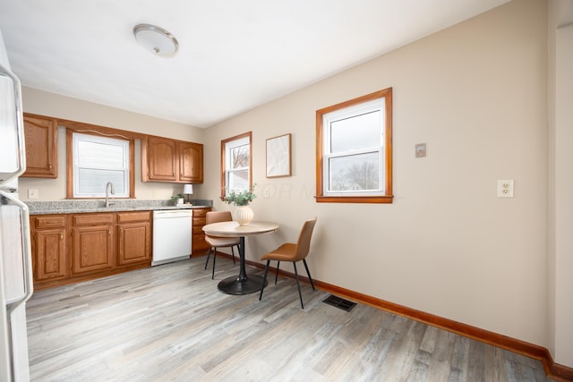 kitchen featuring light wood-type flooring, white appliances, and sink