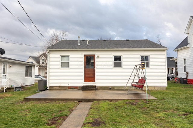 rear view of property featuring cooling unit, a patio area, and a yard