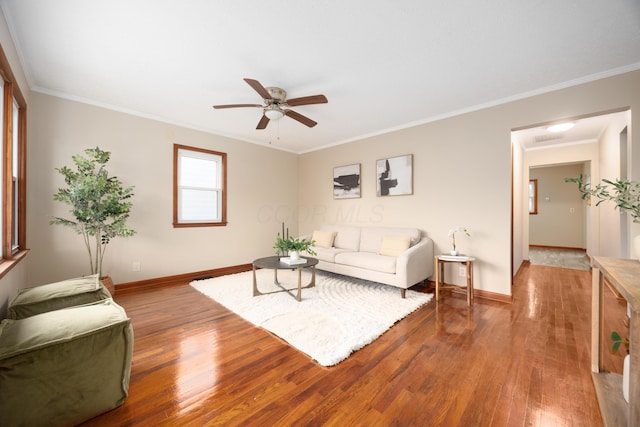 living room featuring hardwood / wood-style flooring, ceiling fan, and crown molding