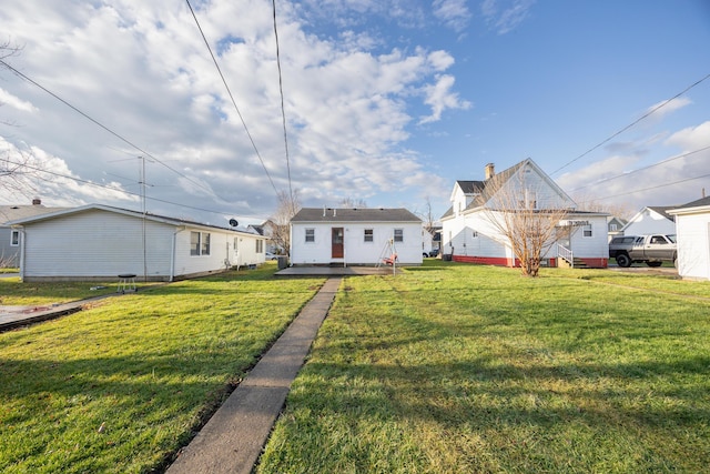 rear view of property featuring a lawn