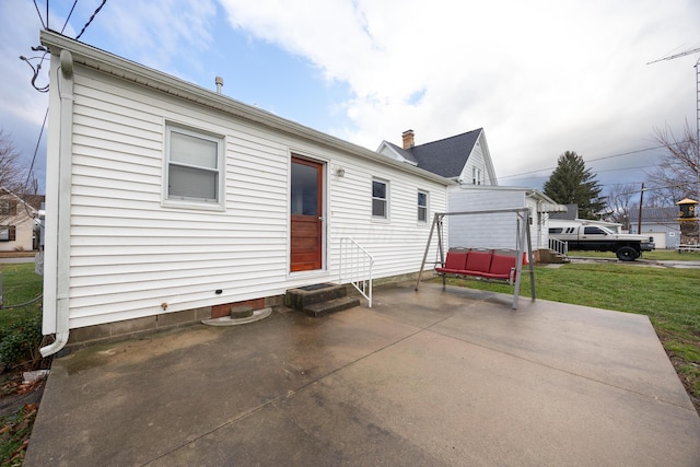 rear view of house with a yard and a patio