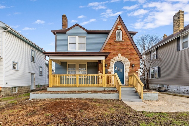 english style home featuring covered porch