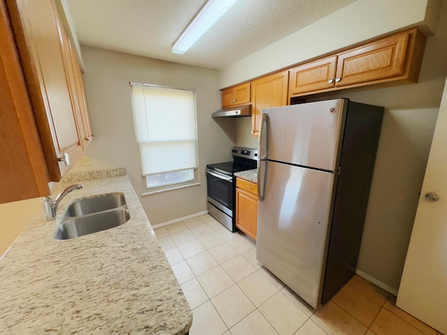 kitchen featuring appliances with stainless steel finishes, a textured ceiling, light tile patterned floors, and sink