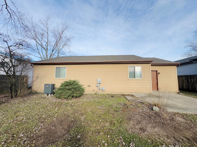 rear view of property with cooling unit and a patio