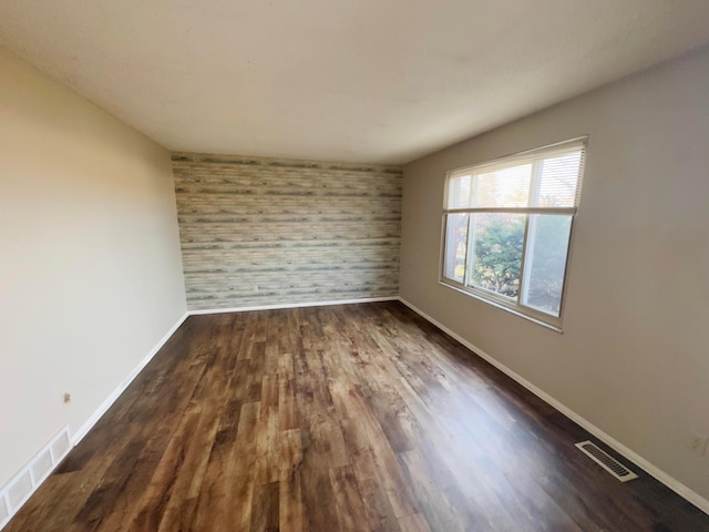 spare room with dark wood-type flooring