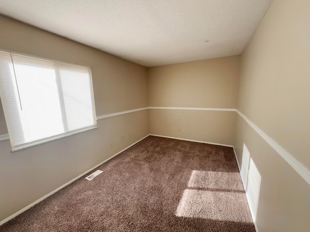 unfurnished room featuring a textured ceiling and carpet floors