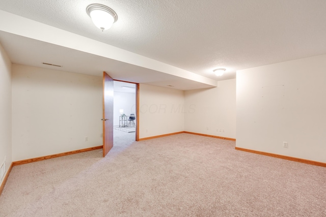 basement with carpet flooring and a textured ceiling