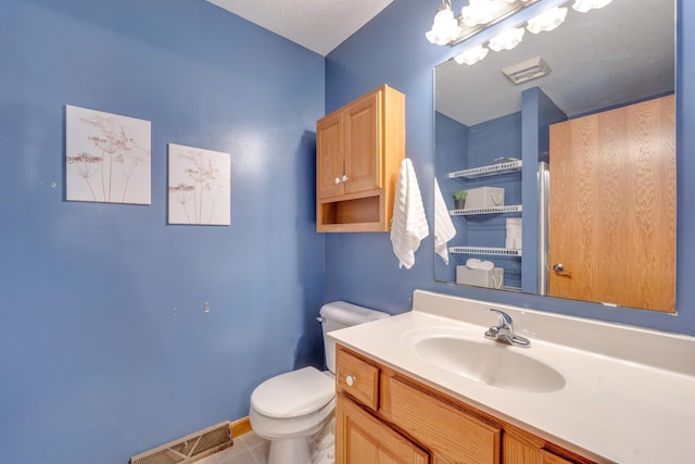 bathroom with tile patterned flooring, vanity, and toilet