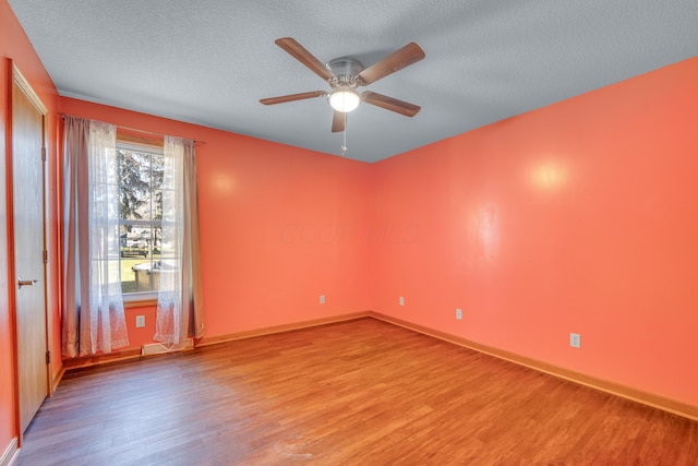 spare room with ceiling fan, a textured ceiling, and light wood-type flooring