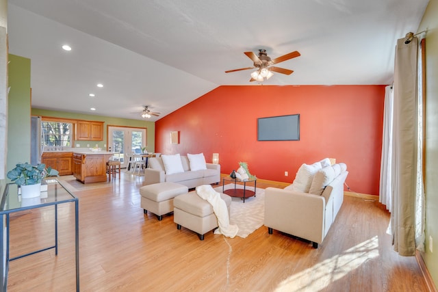 living room featuring french doors, light wood-type flooring, vaulted ceiling, and ceiling fan