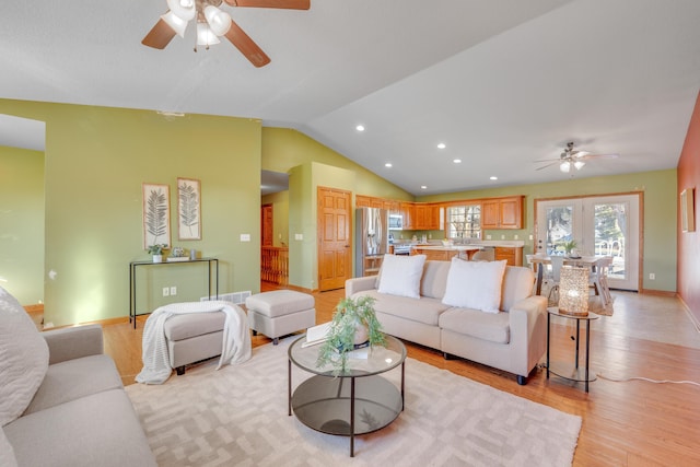 living room featuring ceiling fan, light wood-type flooring, lofted ceiling, and french doors