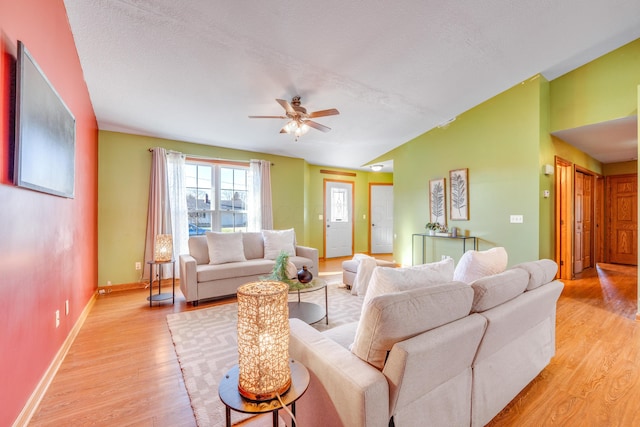 living room featuring a textured ceiling, light hardwood / wood-style flooring, and ceiling fan