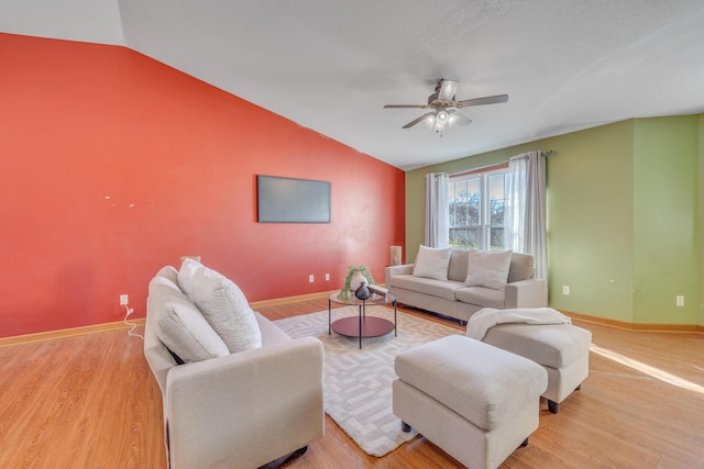 living room featuring a textured ceiling, light hardwood / wood-style flooring, vaulted ceiling, and ceiling fan