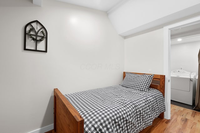 bedroom with vaulted ceiling and light wood-type flooring