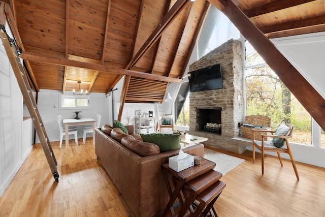 living room with a stone fireplace, wood ceiling, a notable chandelier, and light hardwood / wood-style floors